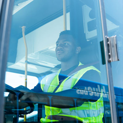 bus driver seen through the blue glass of the bus