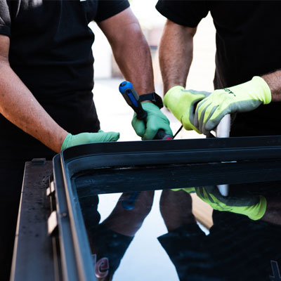 Close-up of technician using tools to replace bus window